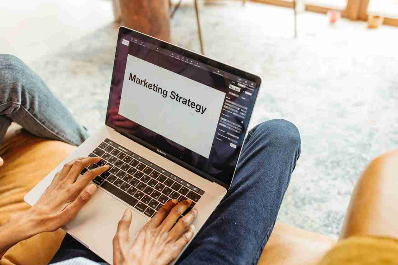 El propietario de una pequeña empresa comprueba el rendimiento de su sitio web en un portátil y sus estrategias de marketing digital